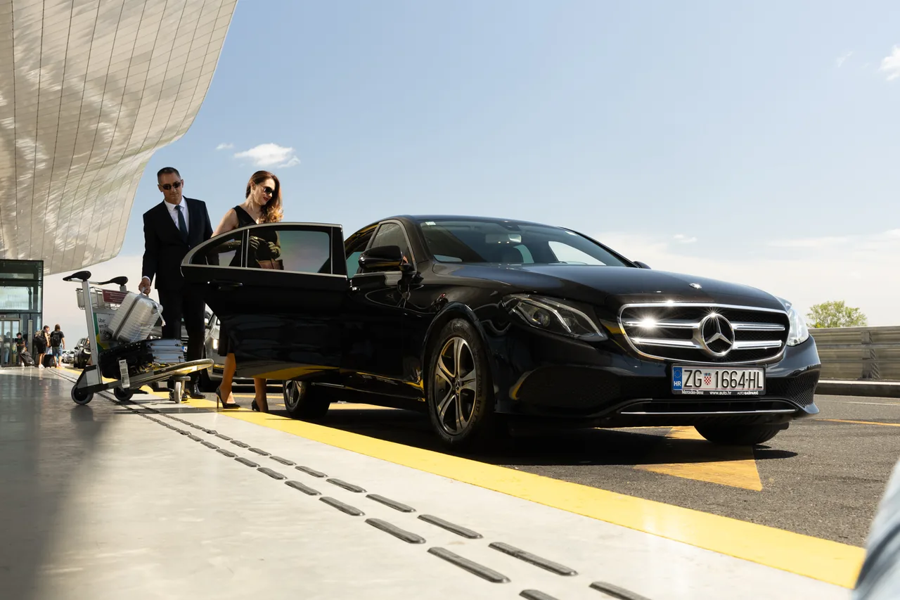 Vozač pomaže putnici uz Mercedes ispred terminala zračne luke Zagreb